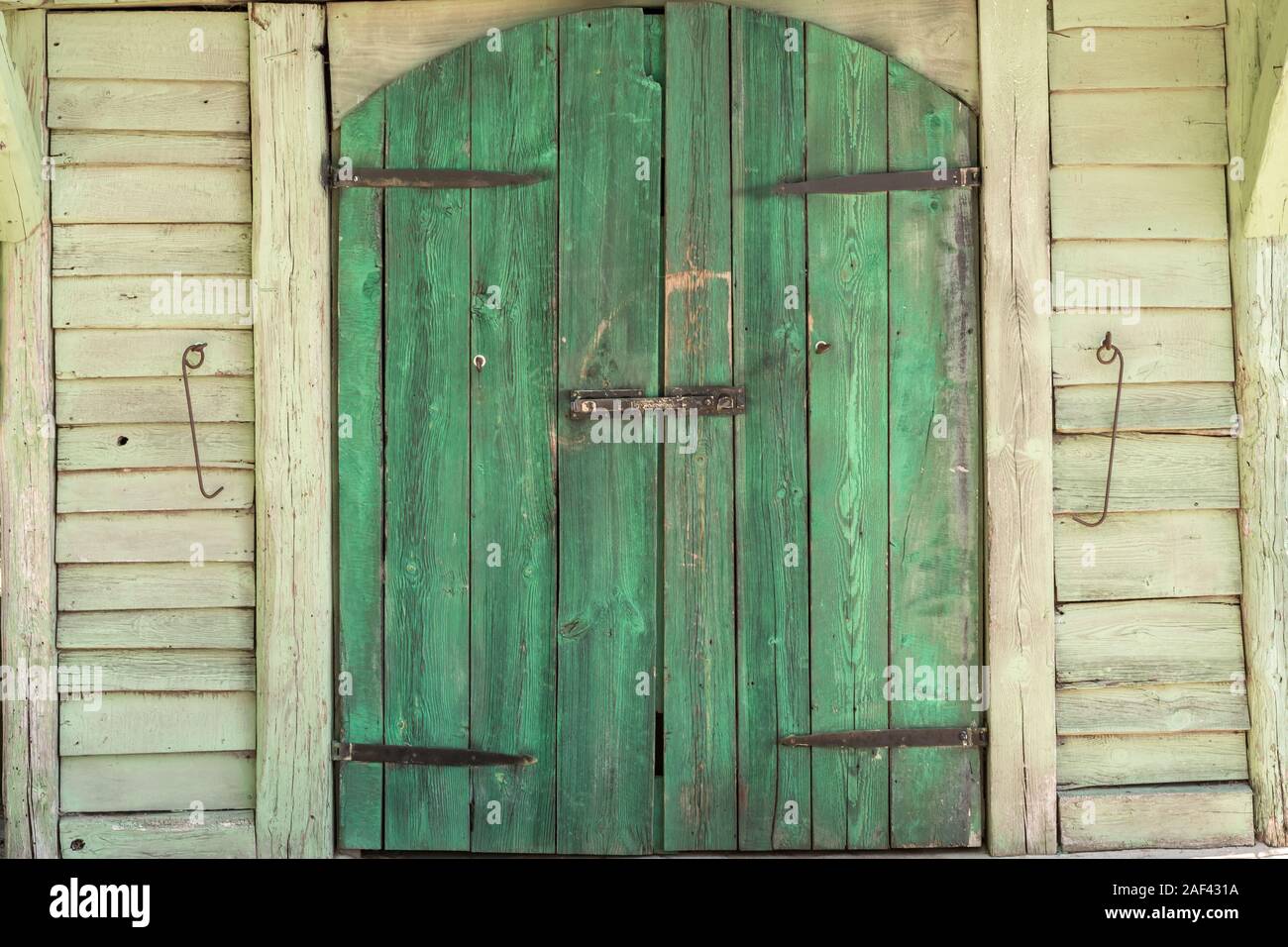 Il verde cancello in legno di un edificio del granaio Foto Stock