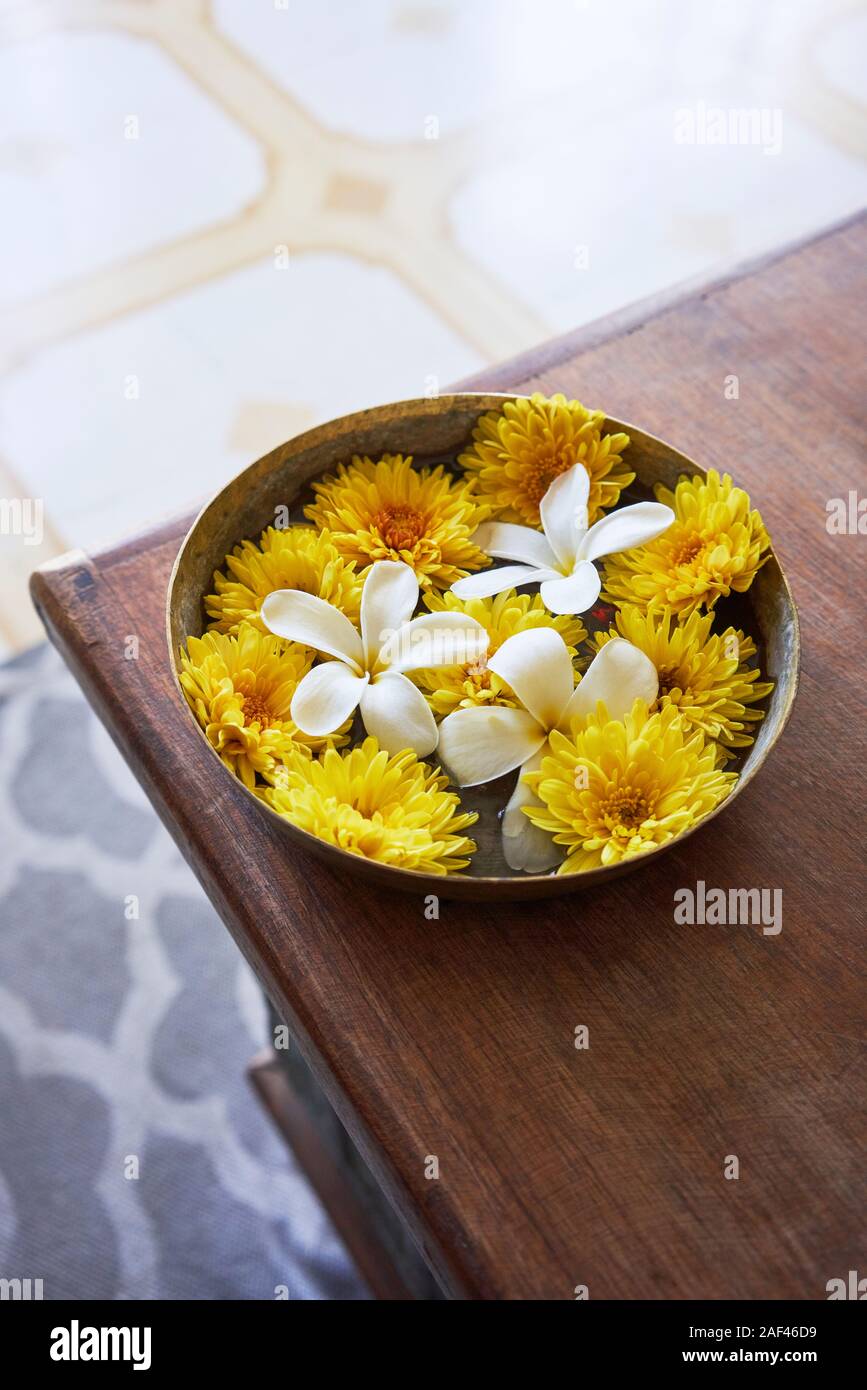 I fiori recisi di seduta in una ciotola di acqua su un tavolo Foto Stock