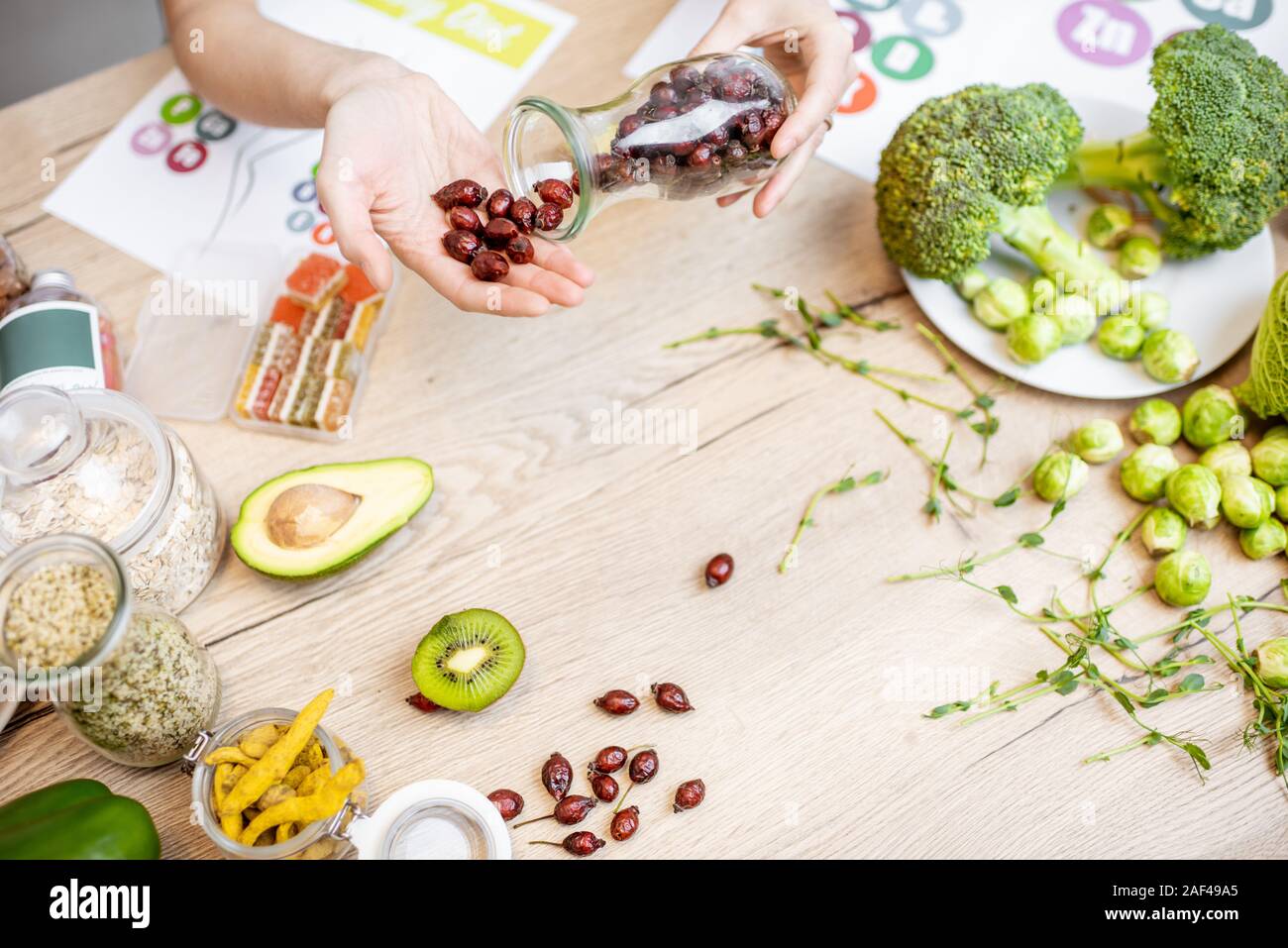 Azienda essiccato rosa canina al tavolo con un sano vegan ingredienti alimentari e supplementi, vista dall'alto. Concetto di rosa canina come una nuova tendenza nel cibo e industria cosmetica Foto Stock