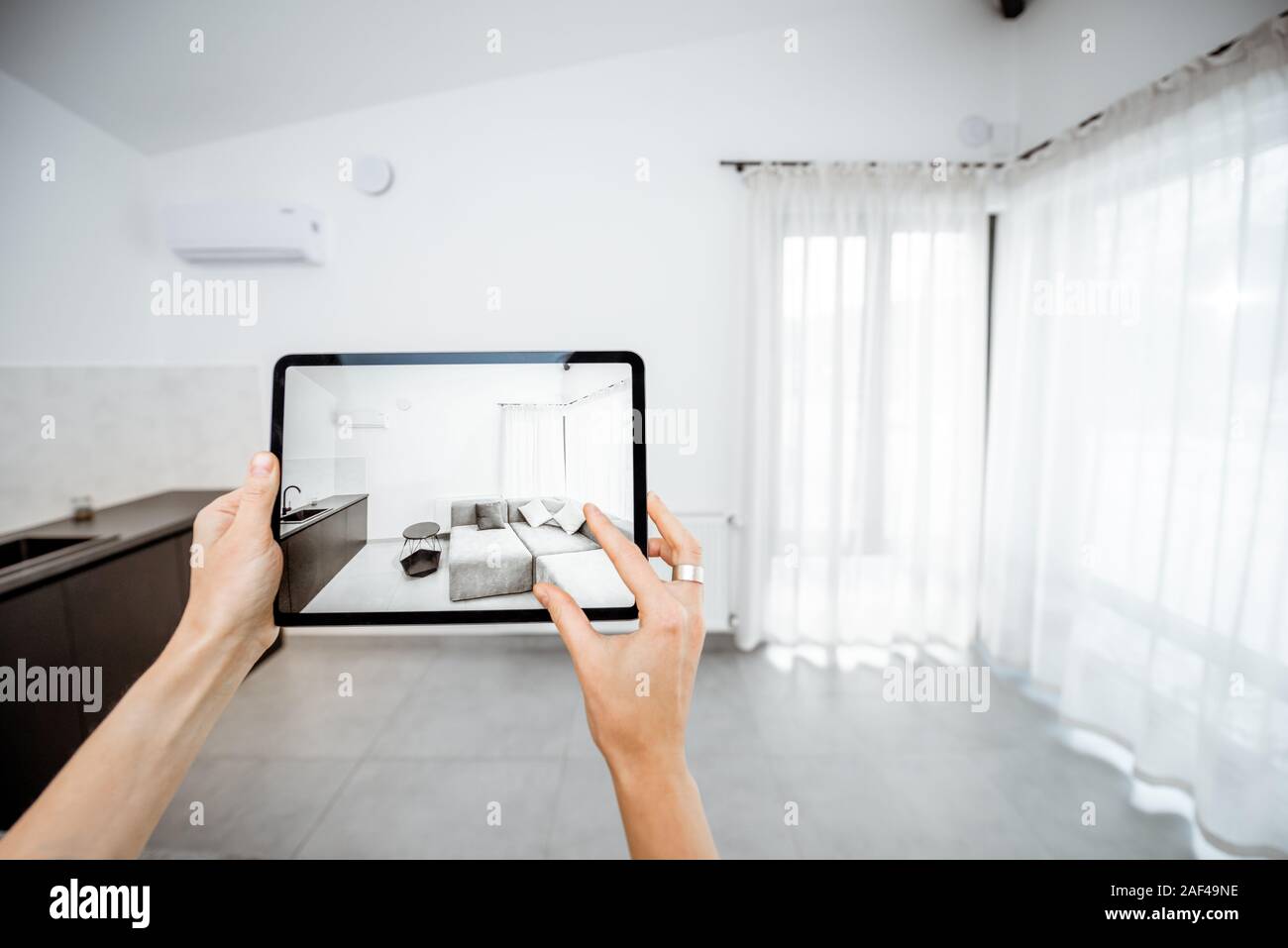 Immissione in commercio di mobili nuovi su una tavoletta digitale nel vuoto interno, guardando come si guarda prima di acquistare. Concetto di realtà aumentata nel design e retail business Foto Stock