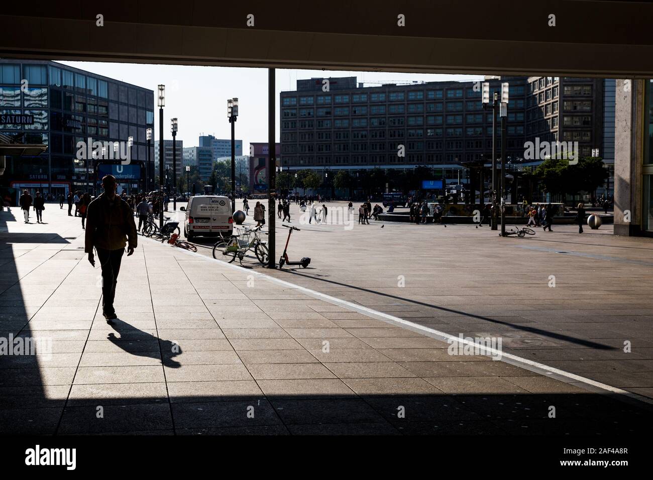 Pedoni profilarsi come essi a piedi attraverso la piazza Alexanderplatz in mattinata a Berlino, Germania. Foto Stock