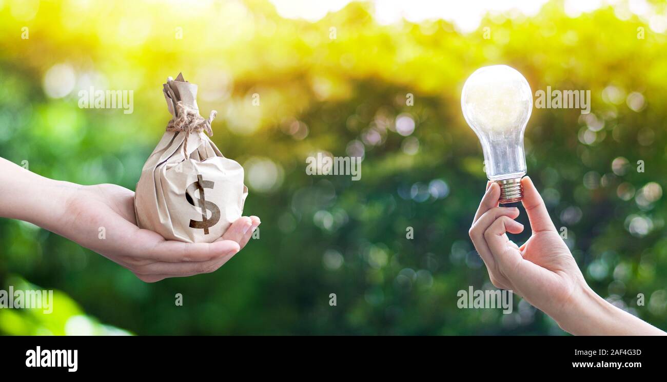 Mano che regge una borsa e una mano che regge una lampada il concetto di Exchange Foto Stock