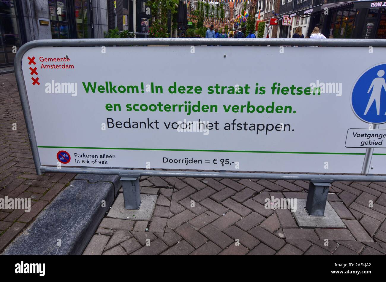Amsterdam, Olanda, Agosto 2019. Un segno eloquente che vieta l'accesso a biciclette e scooter, vi invita a uscire dal veicolo e proseguire a piedi. Foto Stock