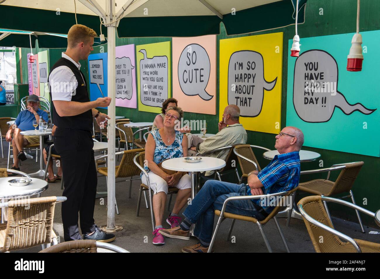 Un paio di parlare a un cameriere in un caffè di Copenhagen, Danimarca Foto Stock