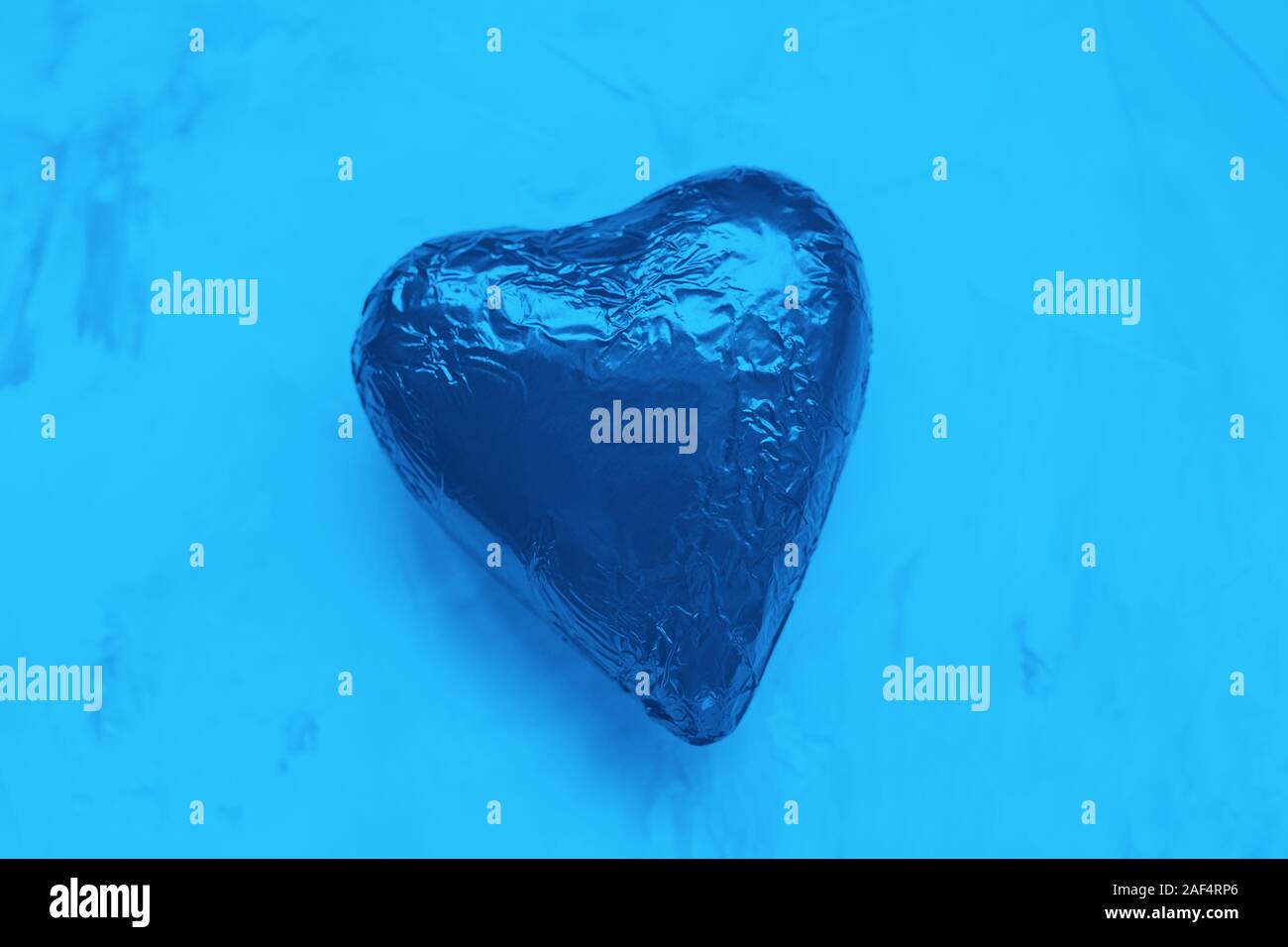 Cuore di cioccolato in lamina. Il giorno di San Valentino concetto, piana, laici spase copia. Il colore Pantone del 2020 Blu classico Foto Stock