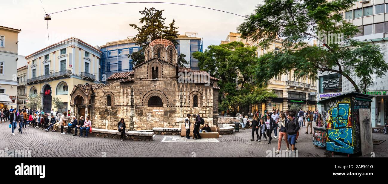 Persone sedute intorno alla vecchia chiesa di Panagia Kapnikarea a Monastiraki, Grecia Foto Stock