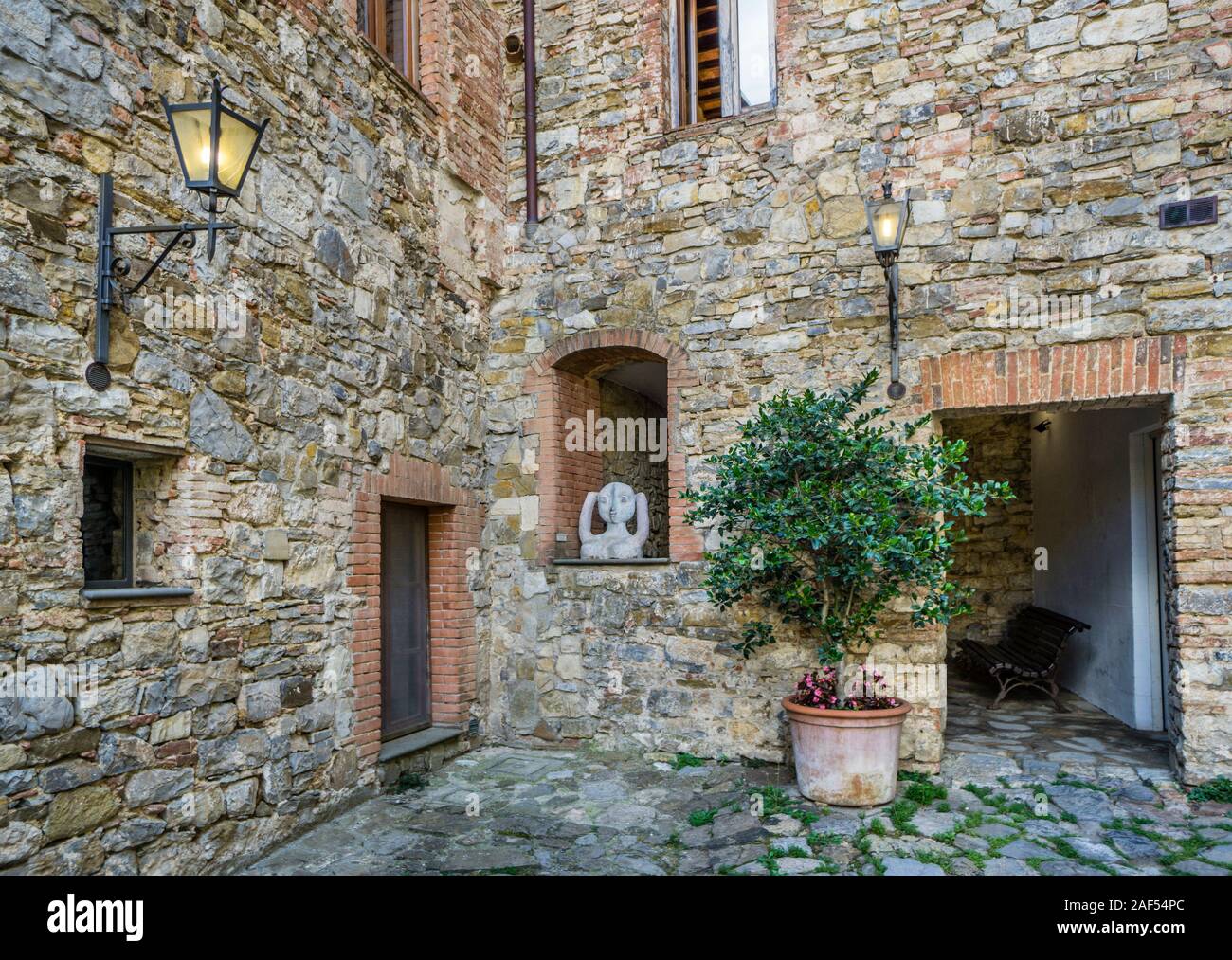 Idilliaco cortile nel borgo medievale di Castellina in Chianti, in provincia di Siena, Toscana, Italia Foto Stock