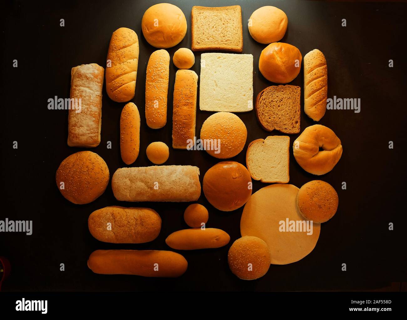 Ancora in vita del pane fresco su sfondo nero. (Hamburger pane, hotdog, grano intero, pane bianco e pane tostato). Foto Stock