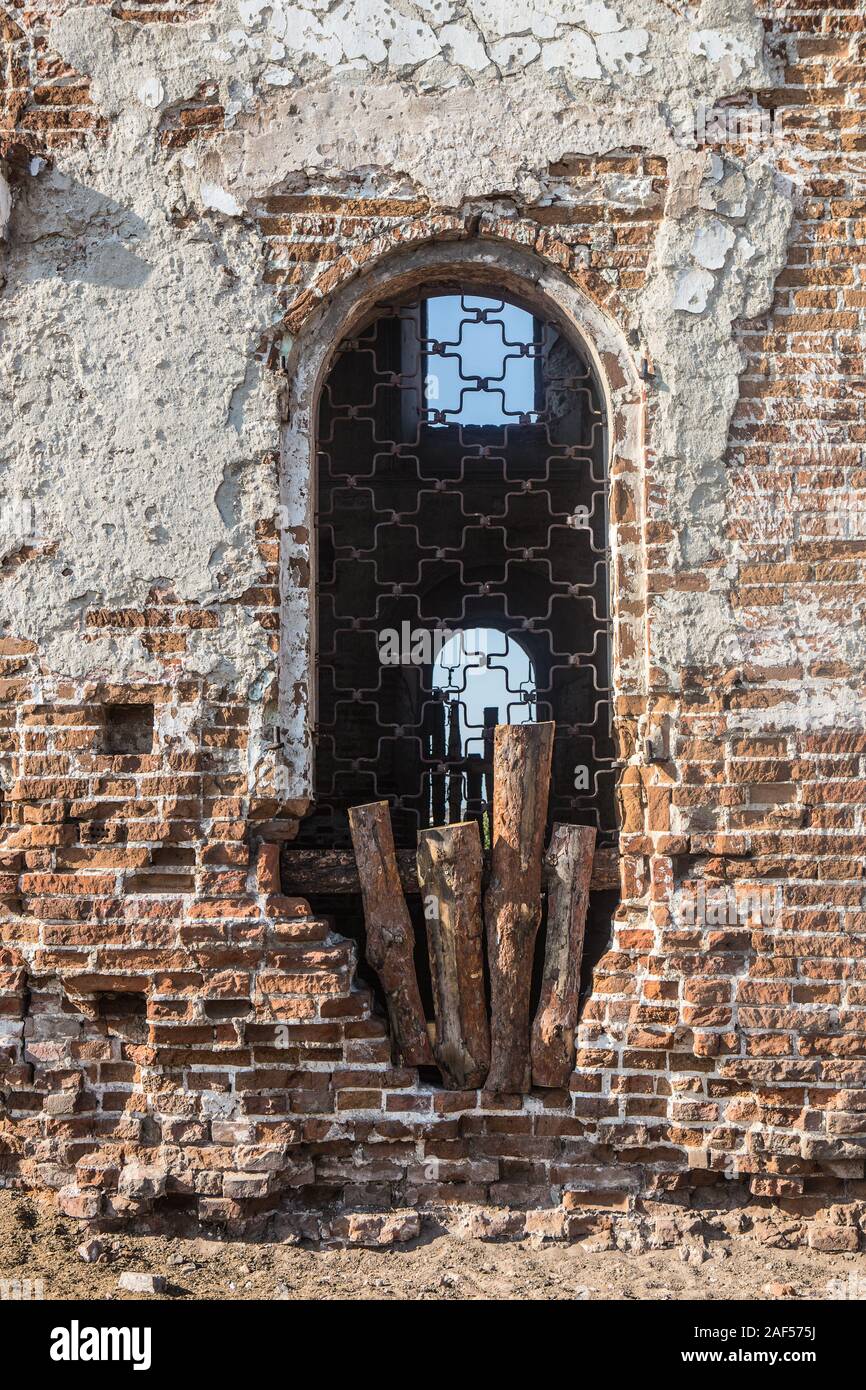 La parete e la finestra ad arco della vecchia chiesa distrutta Foto Stock