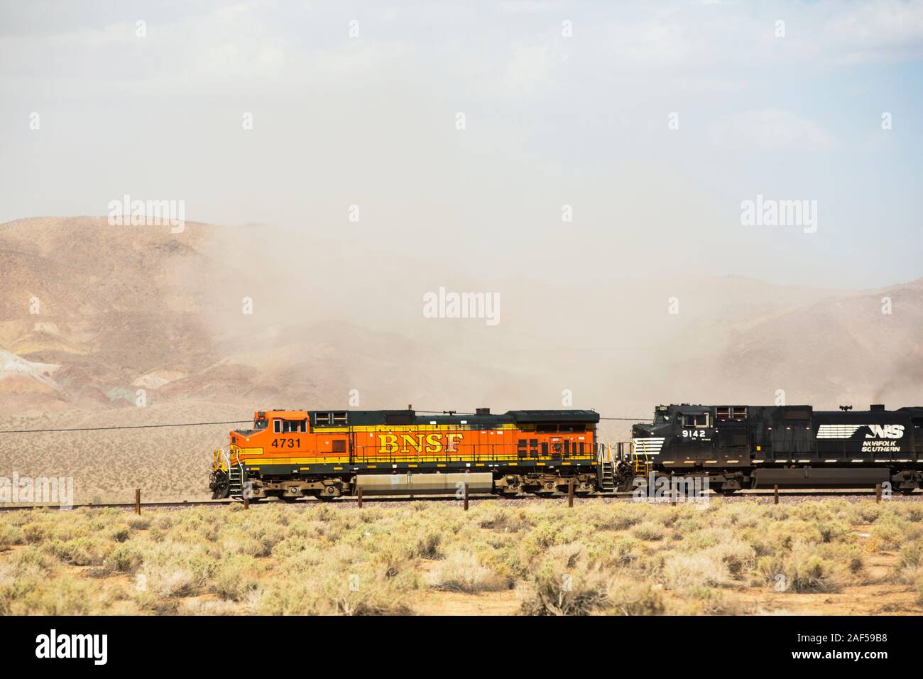 Un treno passa attraverso una tempesta di polvere nel deserto di Mojave in California, Stati Uniti d'America. Foto Stock
