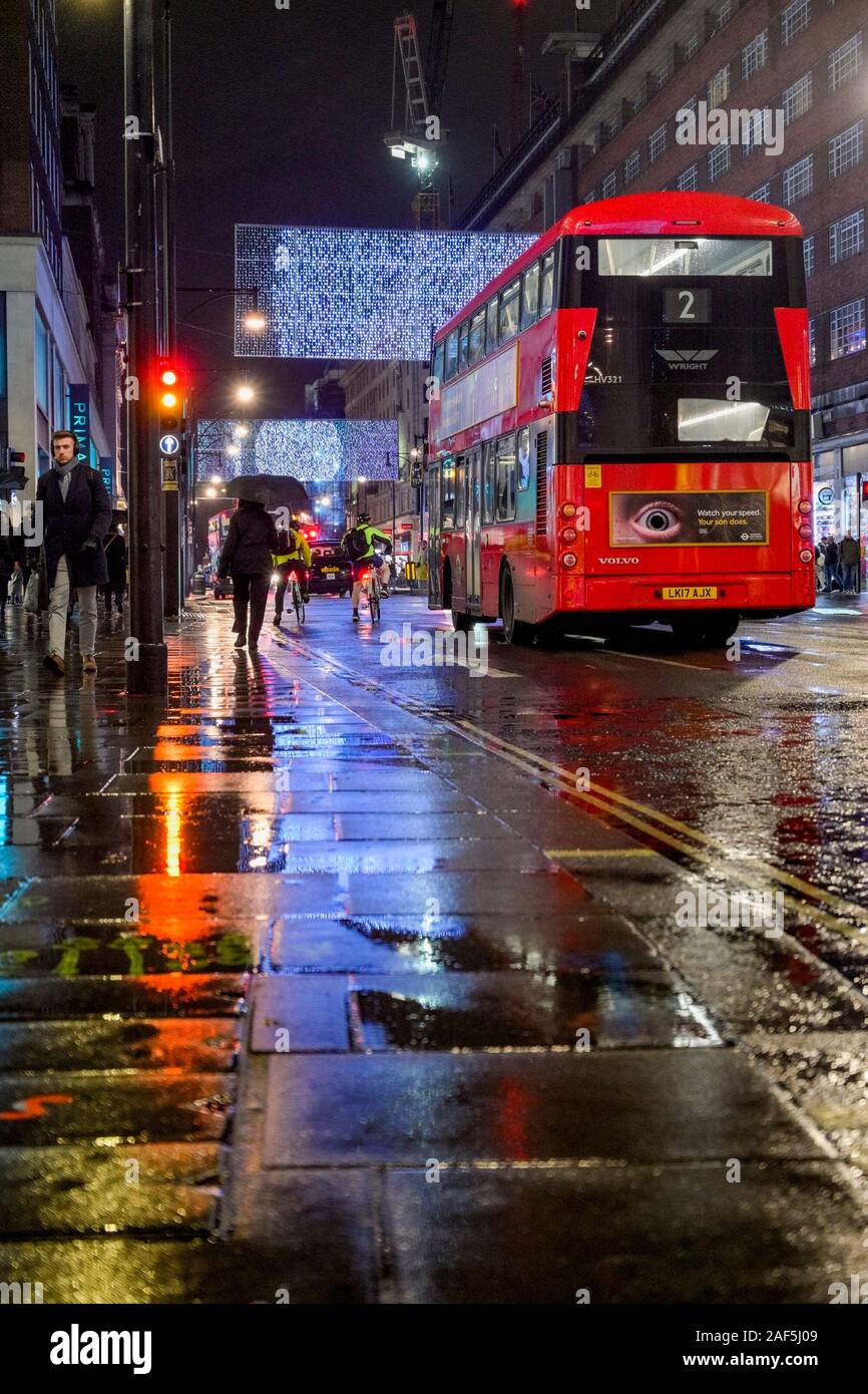 Bus rosso a due piani, su bagnato Oxford Street, notte, Londra, Inghilterra, Regno Unito Foto Stock