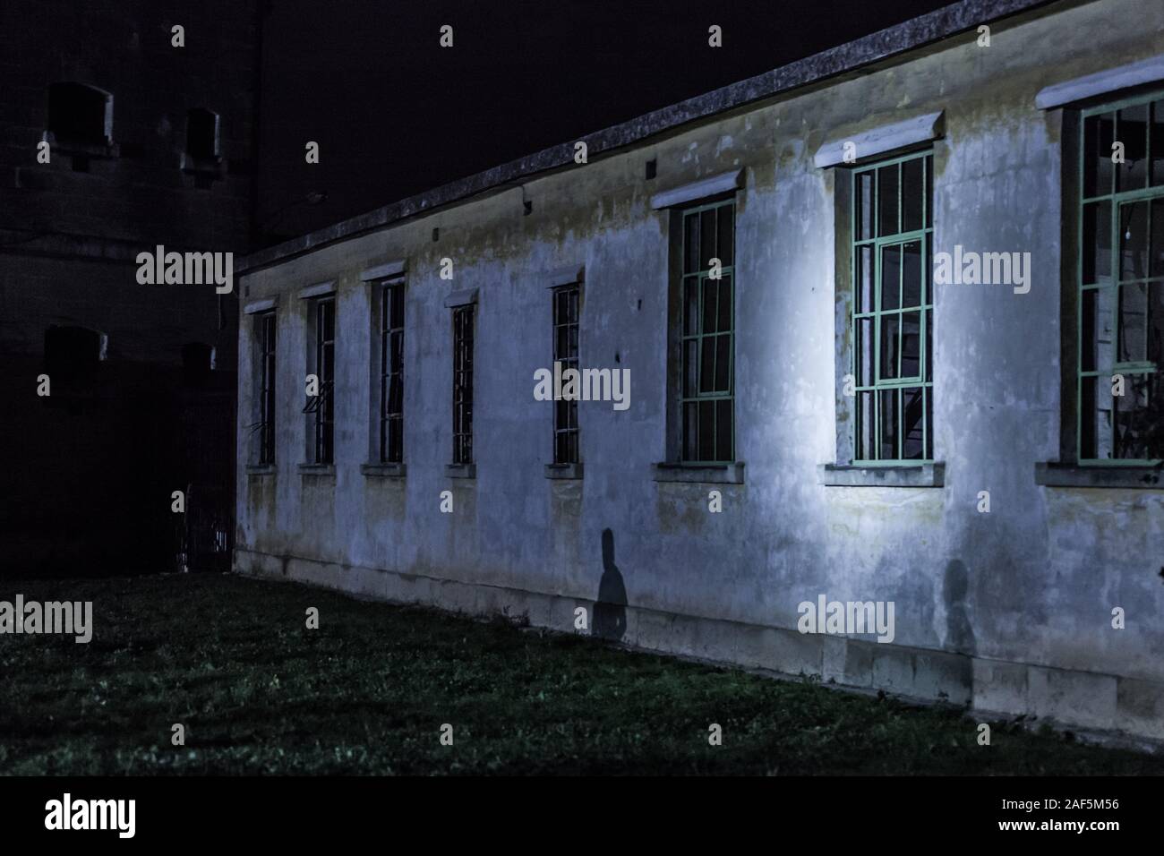 Searchlight glow sulla vecchia prigione edificio Foto Stock