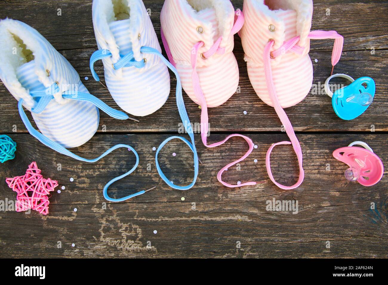 2020 Anno nuovo scritto lacci delle calzature per bambini e ciuccio in legno vecchio sfondo. Foto Stock