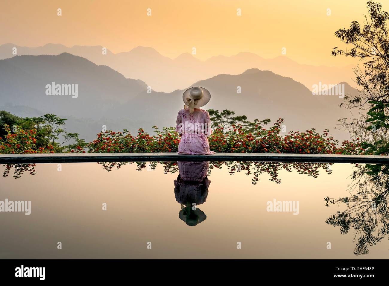 Pu Luong comune, Thanh Hoa provincia, Vietnam - Ottobre 1, 2019: donna asiatica nel vestire in piedi sulla piscina infinity edge e natura scena. Reso di lusso Foto Stock