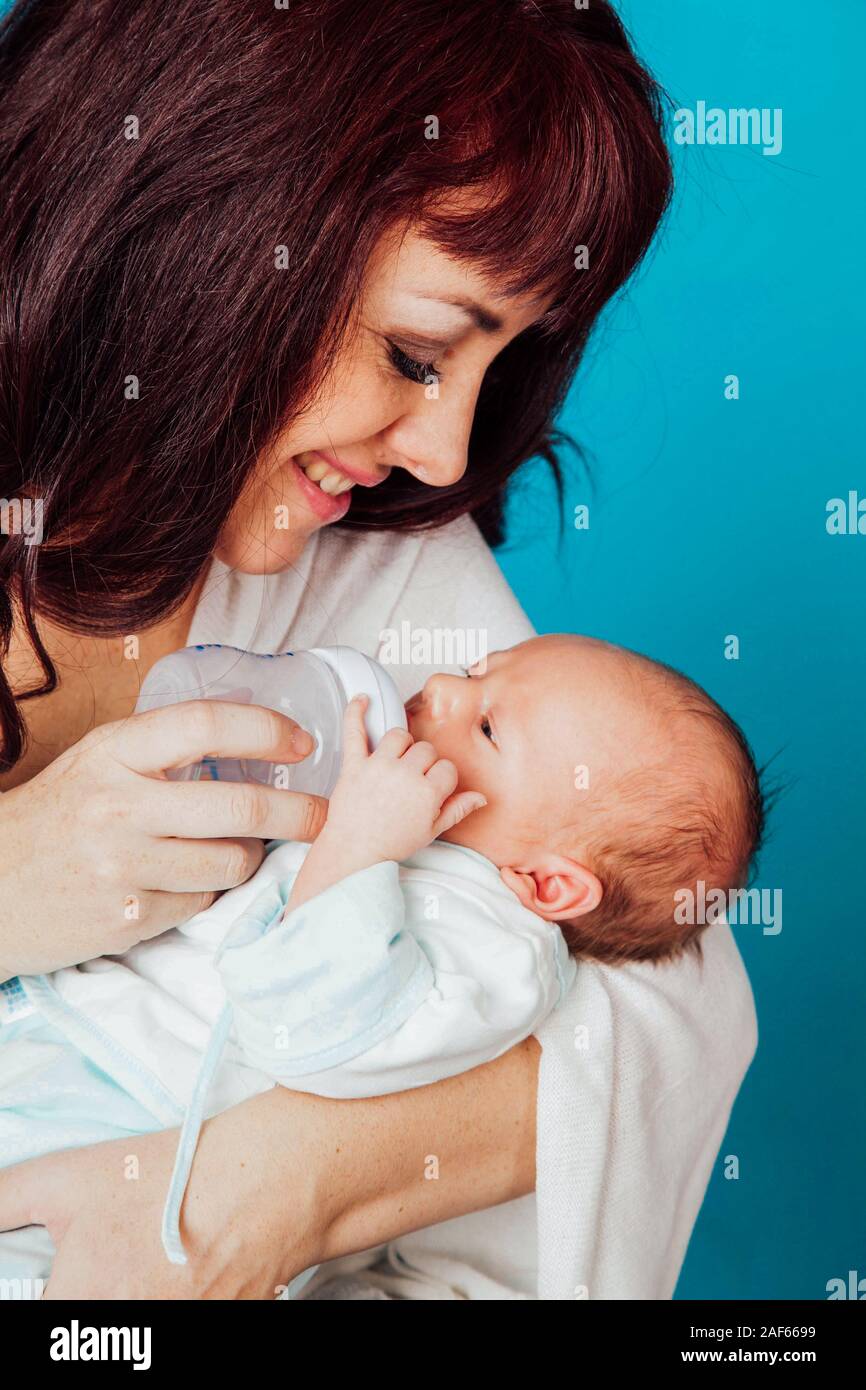 La mamma è la alimentazione del bambino il latte da una bottiglia Foto Stock