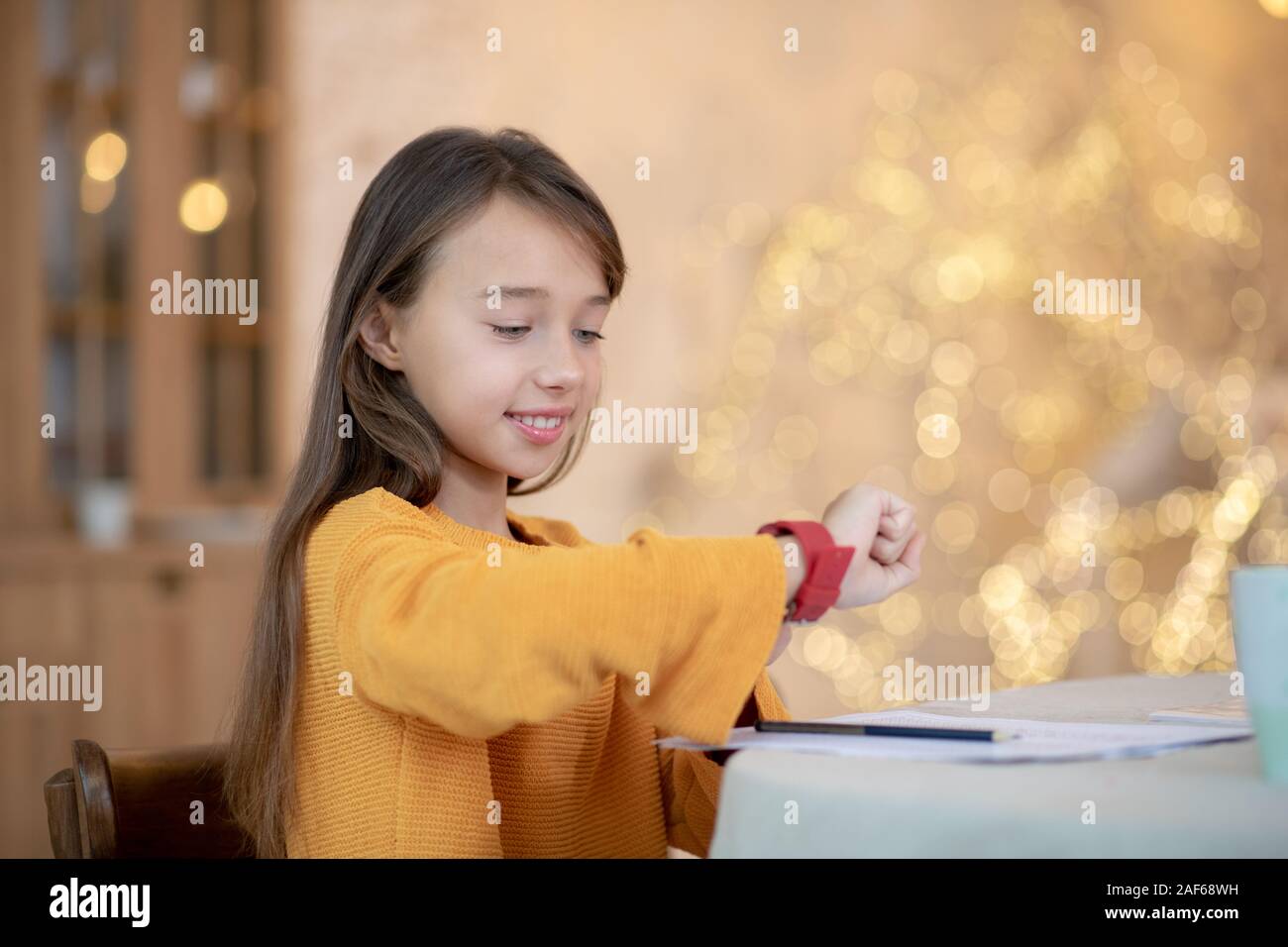 Bella ragazza con i capelli lunghi guardando smartwatch Foto Stock