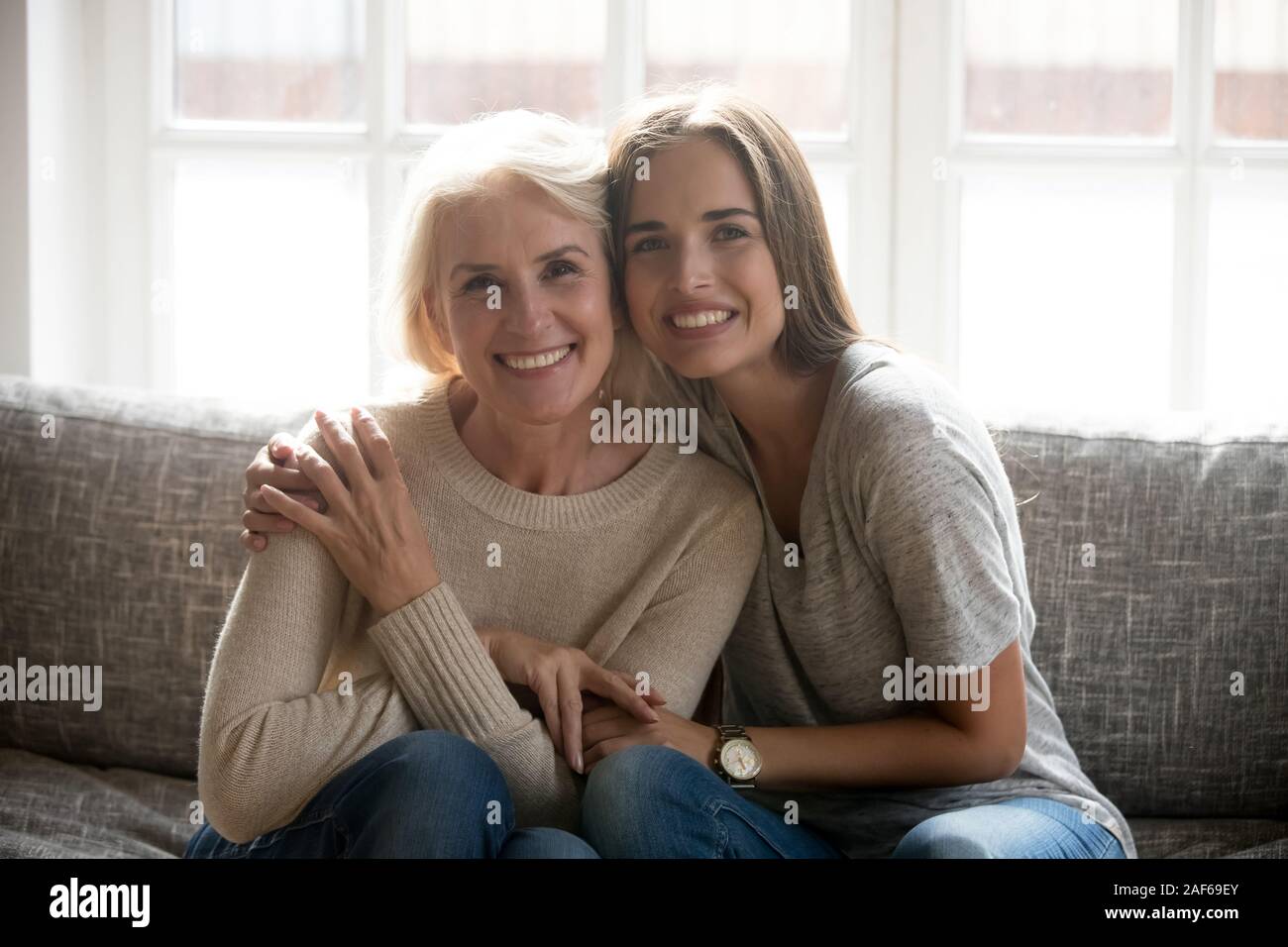 Sorridente mom senior in posa a casa con la figlia adulta Foto Stock