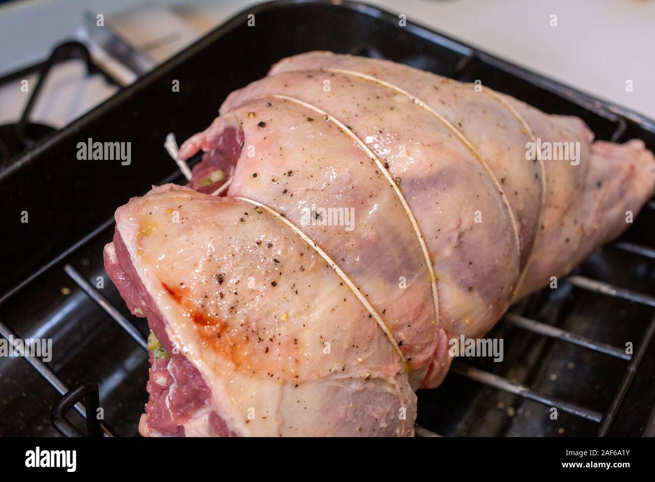 La gamba di agnello farcito e a capriate in preparazione per la tostatura Foto Stock