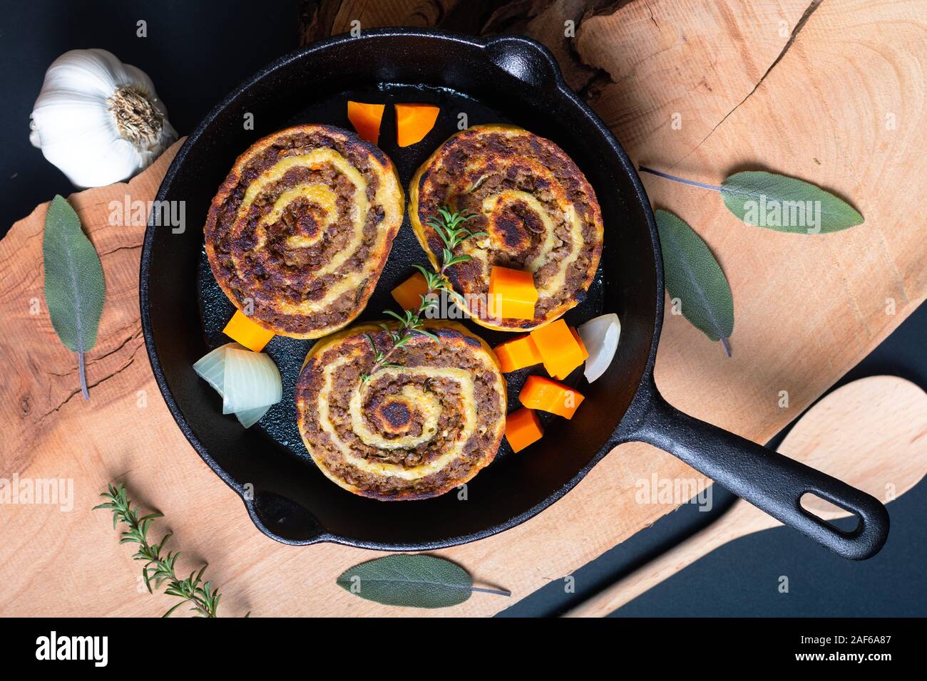 Concetto di cibo Fleischschnackas alsaziano, Alsazia francese cibo locale ripiene di carne in rotolo di uova la pasta nella padella padella di ferro Foto Stock