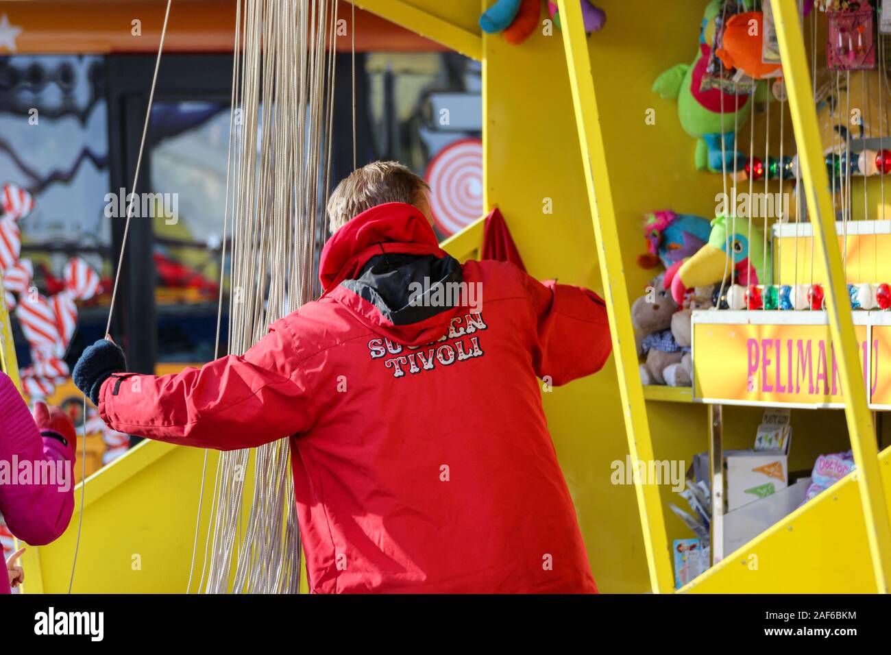 Il viaggio carnevale membro dello staff alla stringa tirare stand Foto Stock