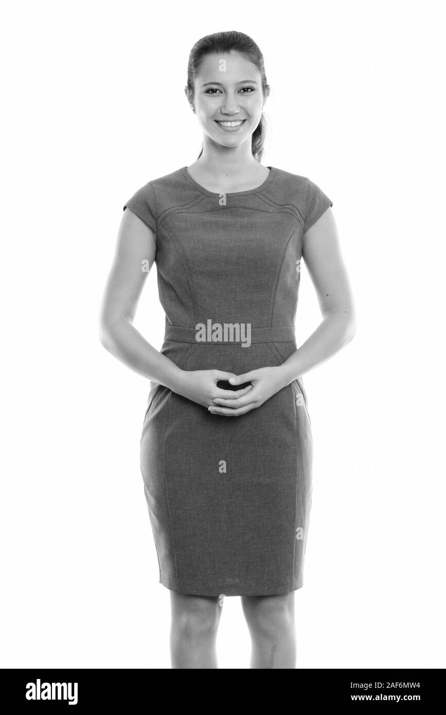Studio shot di giovane imprenditrice felice sorridente e in piedi con le mani insieme Foto Stock