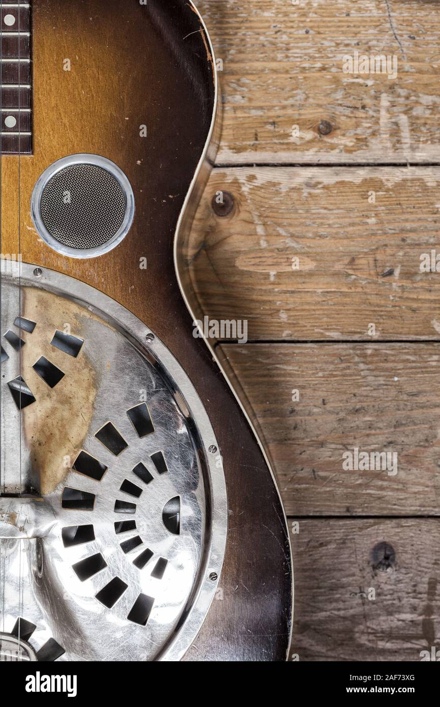 Un dettaglio di un Dobro chitarra su un sfondo di legno Foto Stock