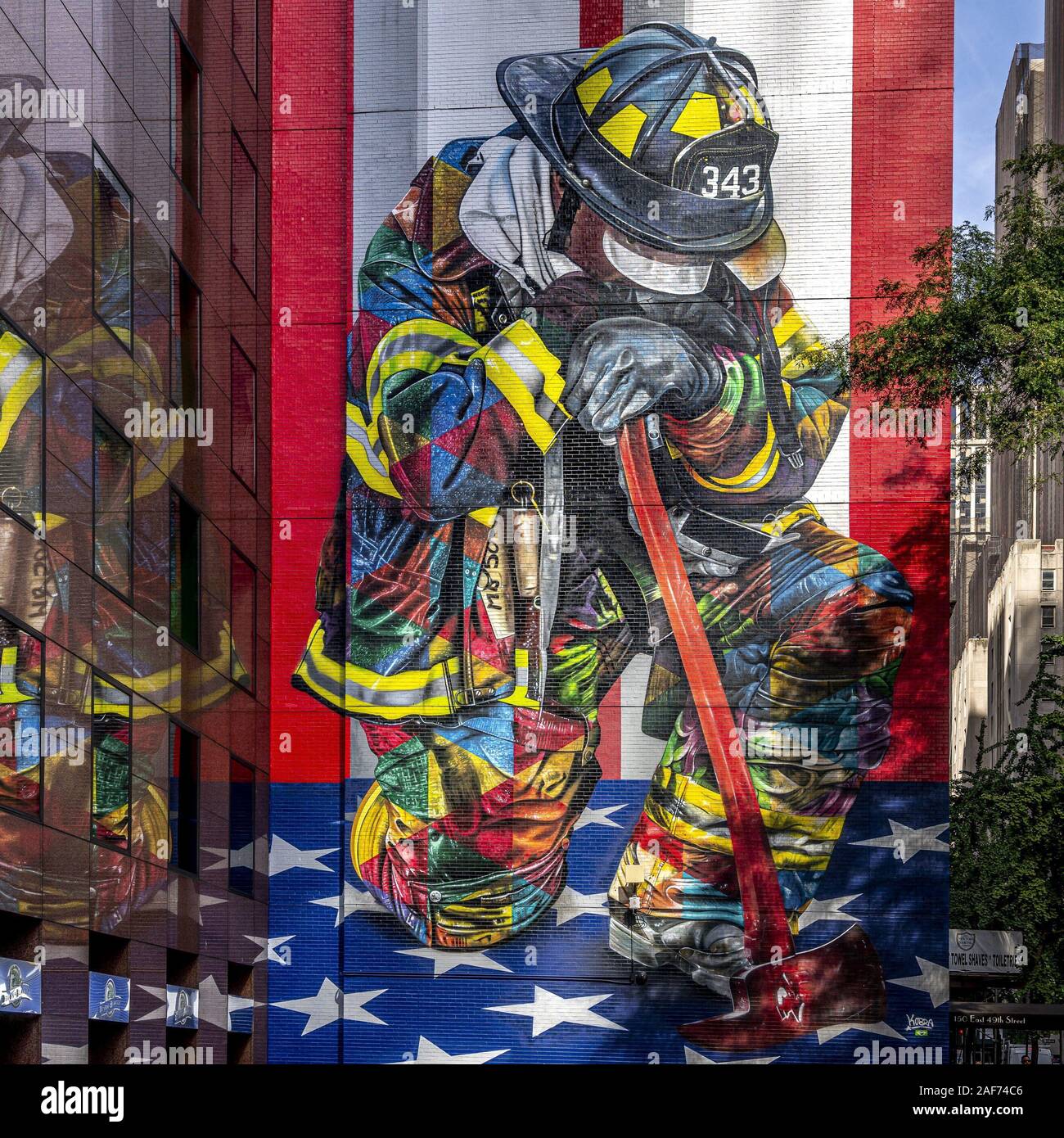 'Il Braves di 9/11' dall'artista brasiliano Eduardo Kobra in New York mostra un lutto fireman in ginocchio di fronte a noi la bandiera con un'ascia e casco. L'immagine commemora i circa 3.000 vittime, tra cui 340 vigili del fuoco. (20 settembre 2019) | utilizzo in tutto il mondo Foto Stock