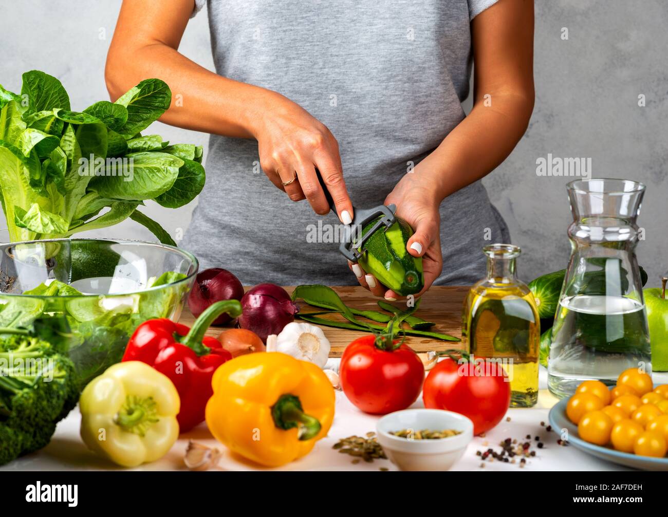 La donna è la pelatura avokado, insalata di cottura in cucina. Una dieta salutare concetto. Foto Stock