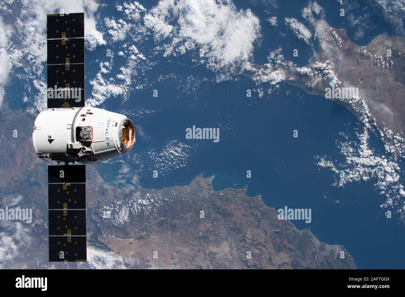 La SpaceX Dragon commerciale capsula di rialimentazione si avvicina alla stazione spaziale internazionale per alle prese dal Canadarm2 braccio robotico 258 miglia al di sopra del Mare Mediterraneo Dicembre 8, 2019 in orbita intorno alla terra. Foto Stock