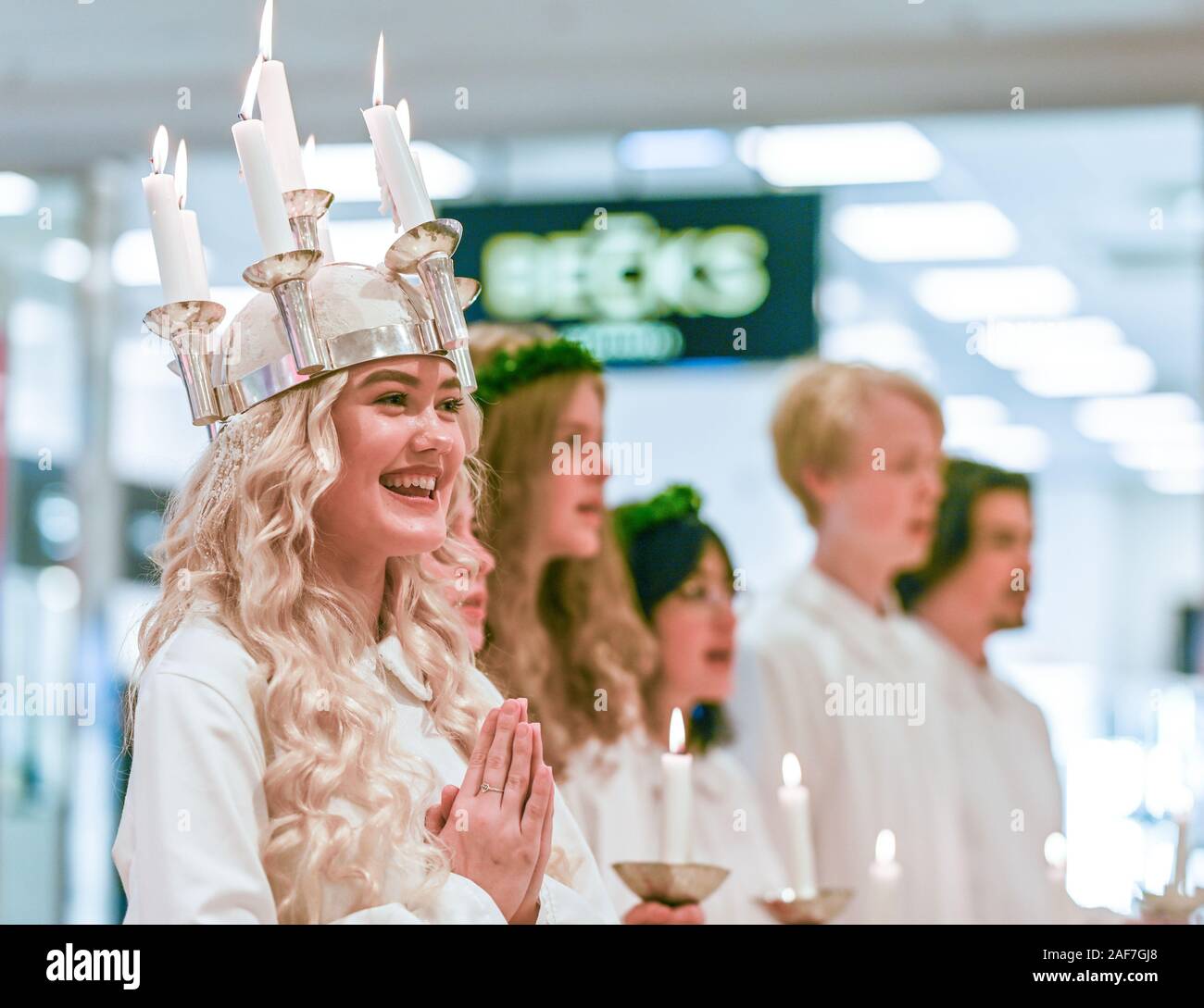 Tradizionale festa di Santa Lucia in Svezia. Norrkoping's Lucia 2019 Izabella Swartz cantando canti natalizi nel centro commerciale di Linden. Foto Stock