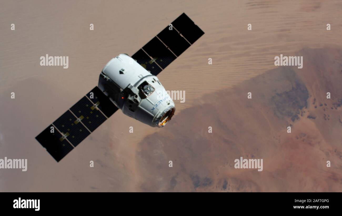 La SpaceX Dragon commerciale capsula di rialimentazione si avvicina alla stazione spaziale internazionale per alle prese dal Canadarm2 braccio robotico 257 miglia al di sopra del Sahara Dicembre 8, 2019 in orbita intorno alla terra. Foto Stock