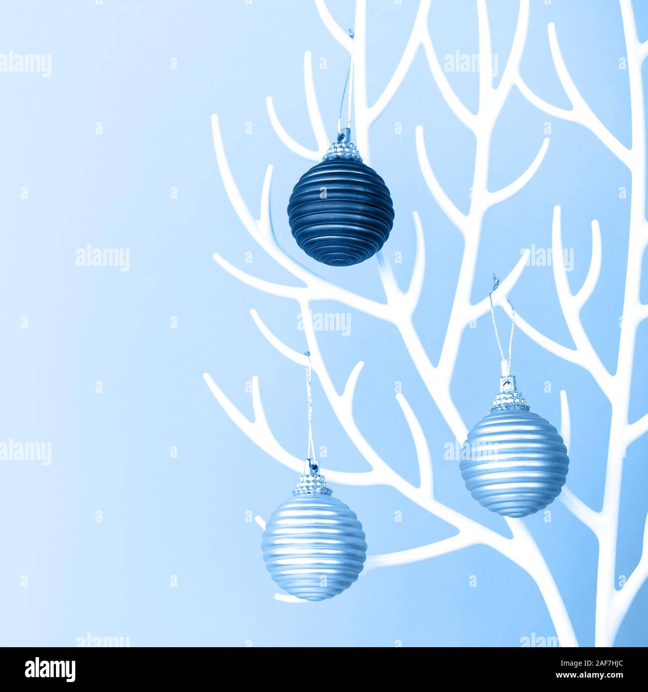 Albero di Natale fatto di plastica bianca di corna e ninnolo decorazione sul blu Foto Stock