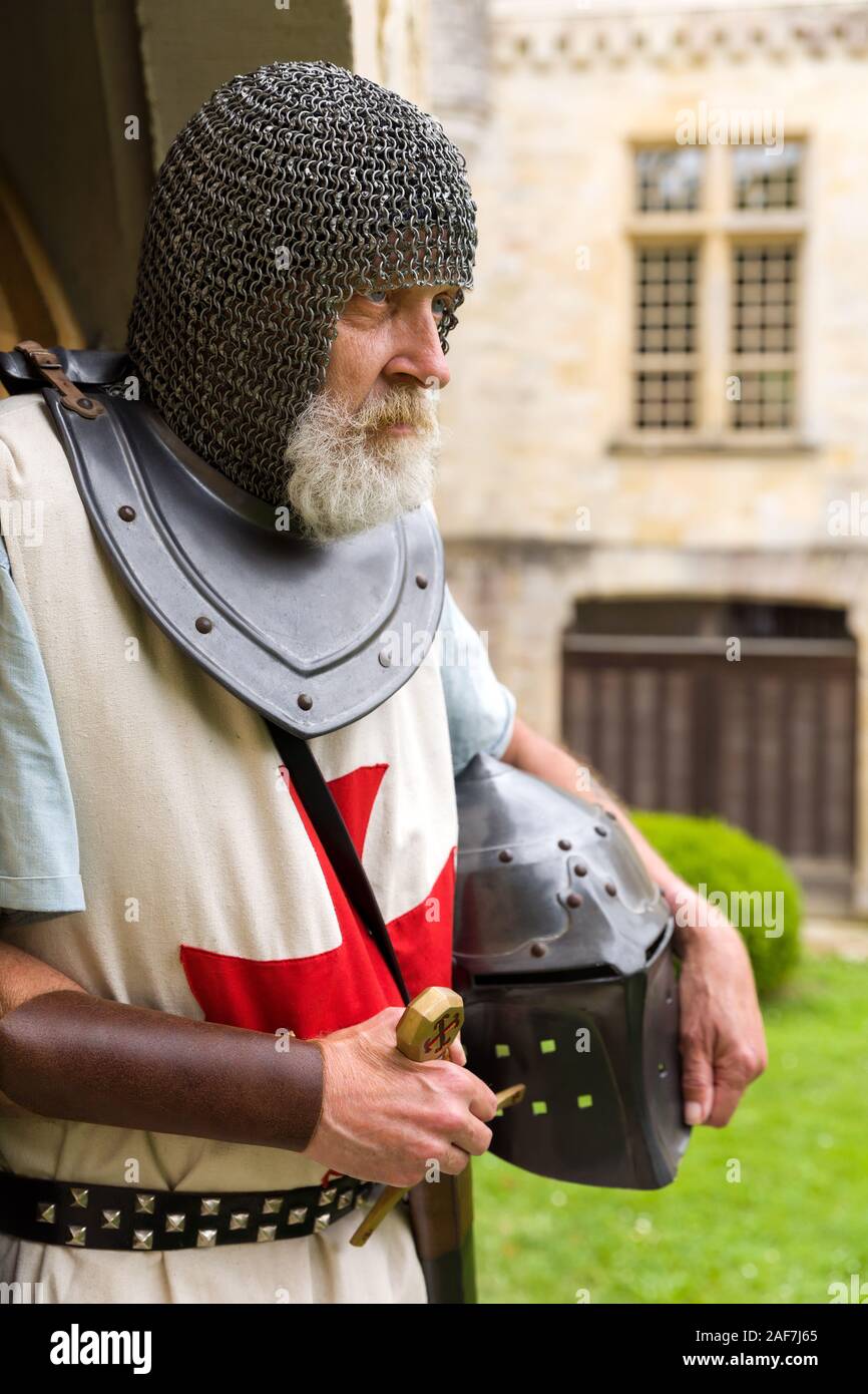 Posa all'aperto di un uomo vestito in autentici Cavaliere Templare vestito o costume crociato in piedi contro uno sfondo di un medievale castello francese Foto Stock