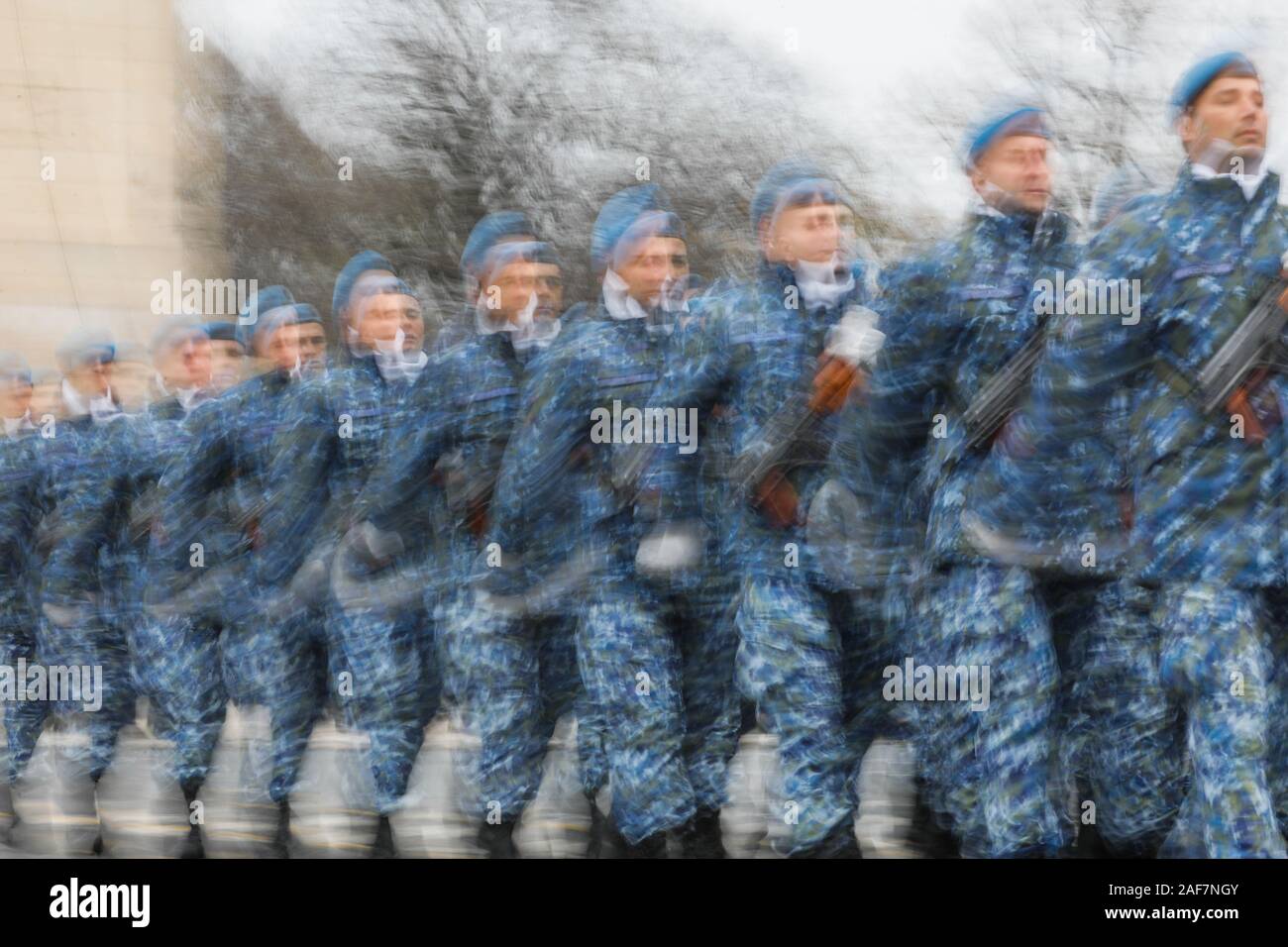 Panoramica intenzionalmente (lente e la velocità dello shutter di sfocatura) immagine di soldati che marciano. Foto Stock