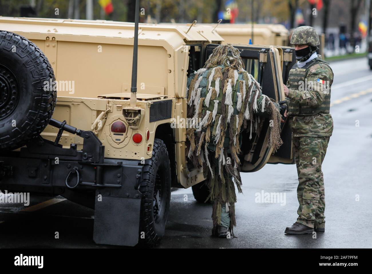 Bucarest, Romania - 01 dicembre, 2019: tuta Gillie soldati entra in un esercito rumeno elevata mobilità multiuso di veicolo su ruote (HMMWV, Humv colloquiale Foto Stock
