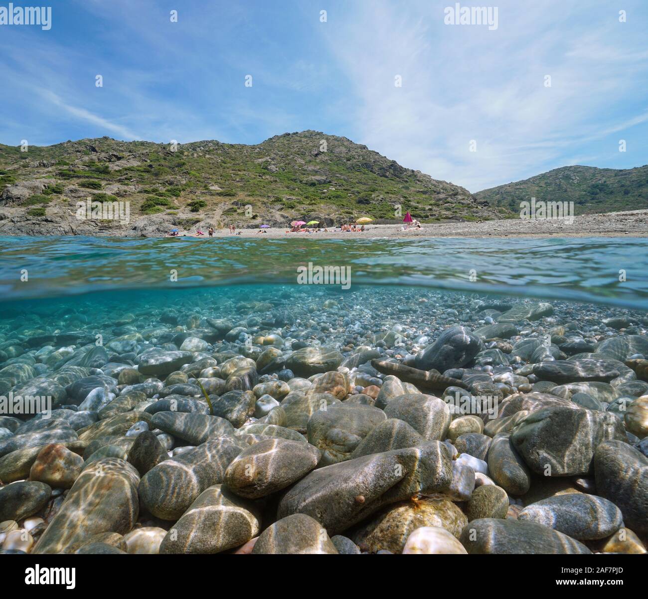 Spagna mare mediterraneo, spiaggia shore in estate con i ciottoli rocce sottomarine, vista suddivisa al di sopra e al di sotto della superficie, Costa Brava, El Port de la Selva Foto Stock