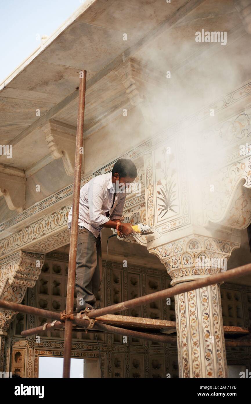 Indian uomo facendo lavori di restauro dal macinino attrezzo. Agra Fort Agra, India, 01.12.2019 Foto Stock