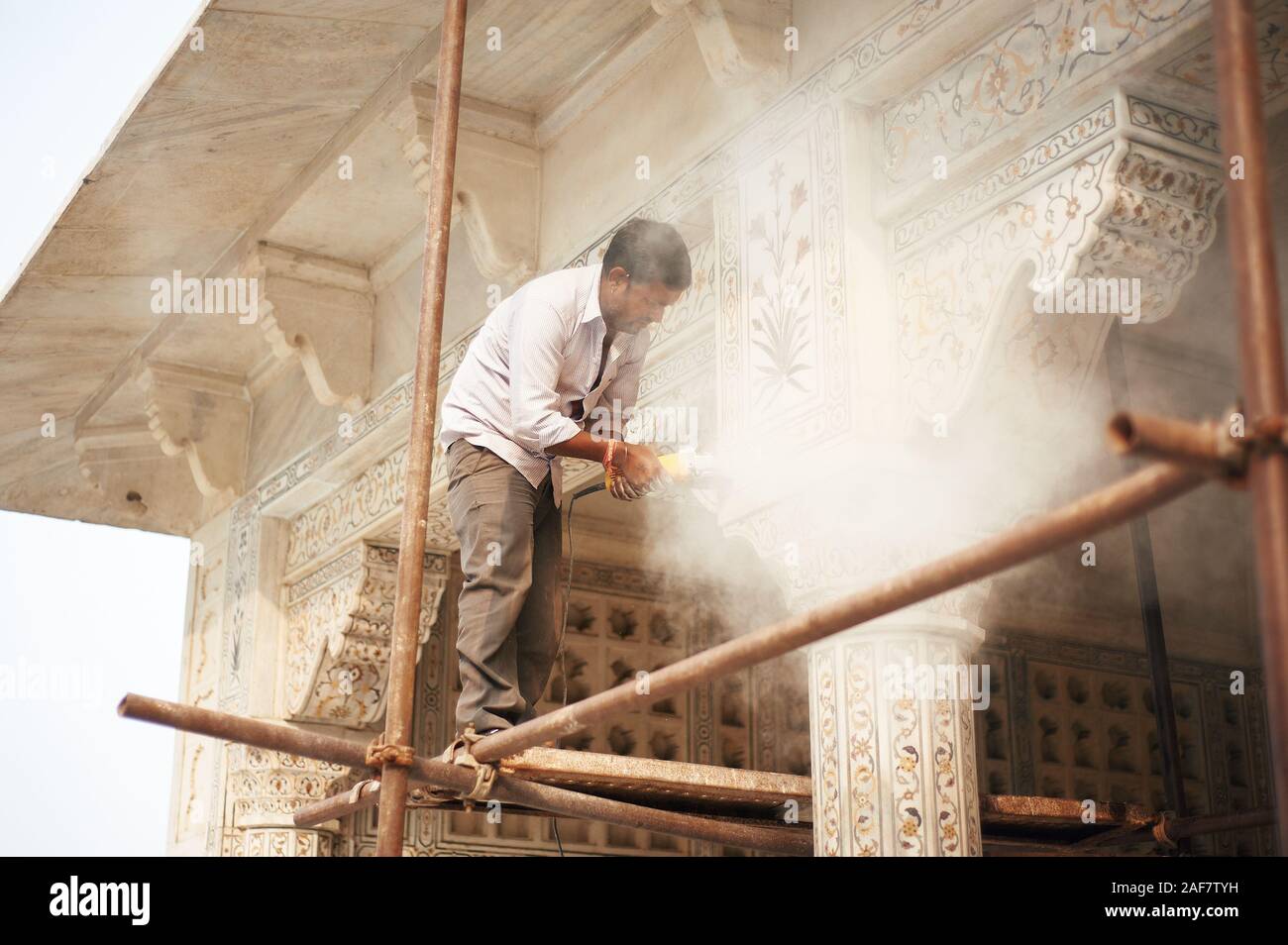 Indian uomo facendo lavori di restauro dal macinino attrezzo. Agra Fort Agra, India, 01.12.2019 Foto Stock