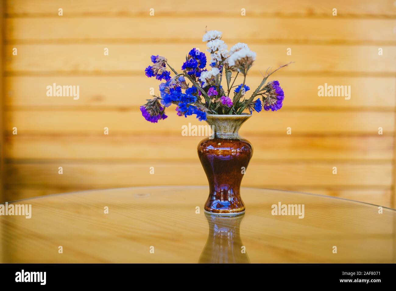 Bellissimi fiori viola mazzetto sul tavolo di vetro con la luce del sole e la stagione estiva. : La foto in stile vintage. Fiori viola in una tabella in un cafe Foto Stock