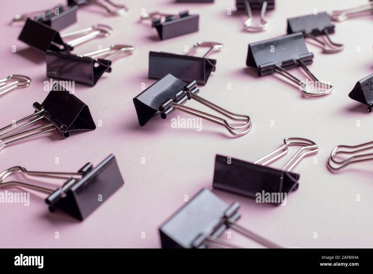Molti uffici binder clip sulla carta rosa Foto Stock