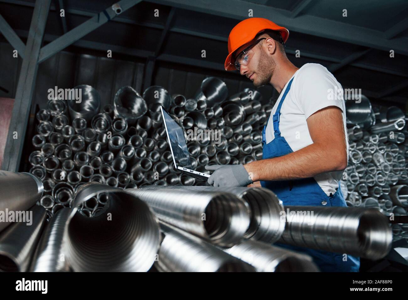 Realizzati con acciaio speciale. Uomo in uniforme lavora sulla produzione. Industriale la tecnologia moderna Foto Stock