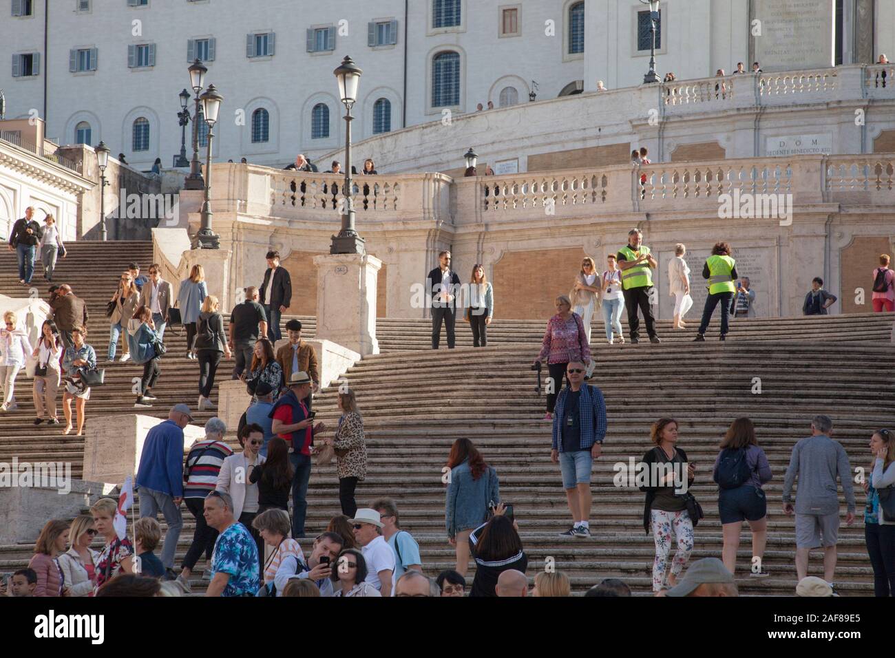Le guardie di sicurezza sulla Scalinata di piazza di Spagna a Roma turisti stop sedersi per evitare la congestione attorno ad una popolare attrazione Foto Stock