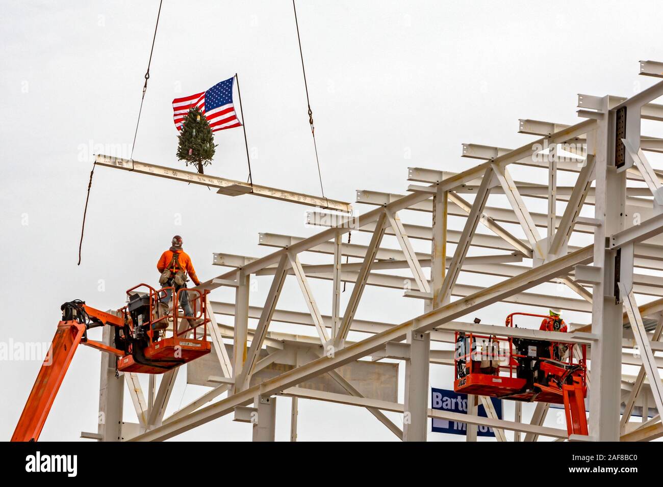 Detroit, Michigan STATI UNITI D'America - 13 dicembre 2019 - lavoratori edili sollevare una bandiera e un albero di Natale l'ultimo pezzo di acciaio strutturale di essere collocati su Chrysler Fiat è di nuovo impianto di assemblaggio di autoveicoli. È il primo nuovo impianto di assemblaggio per essere costruito a Detroit in 30 anni. Credito: Jim West/Alamy Live News Foto Stock