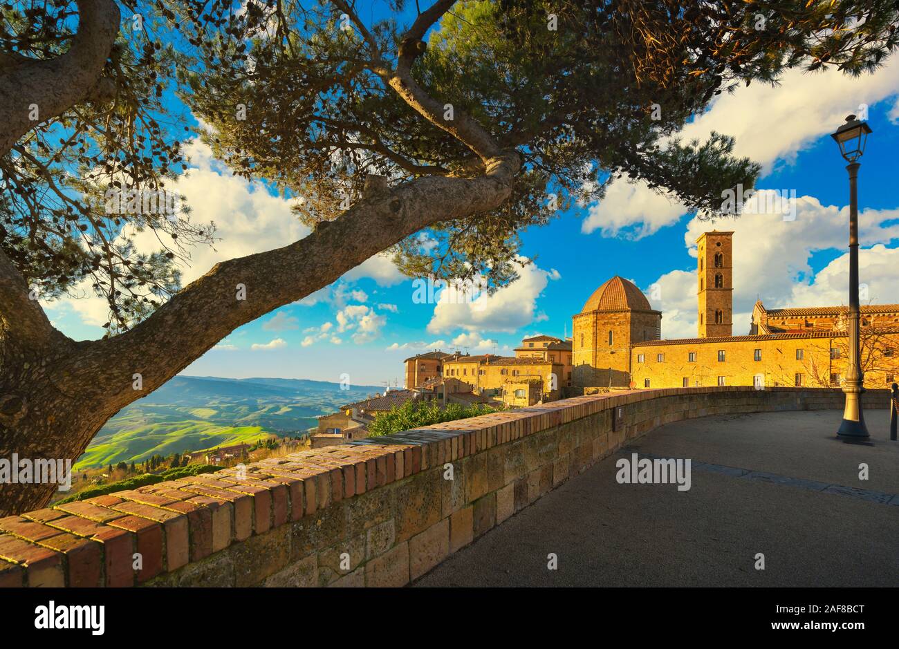 Toscana, Volterra città skyline, chiesa e gli alberi sul tramonto. La Maremma, Italia, Europa Foto Stock