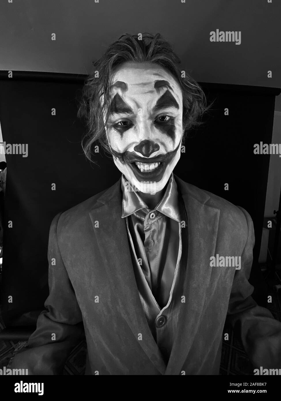 Ritratto di un uomo in un vestito con clown trucco e i capelli verdi. Foto Stock