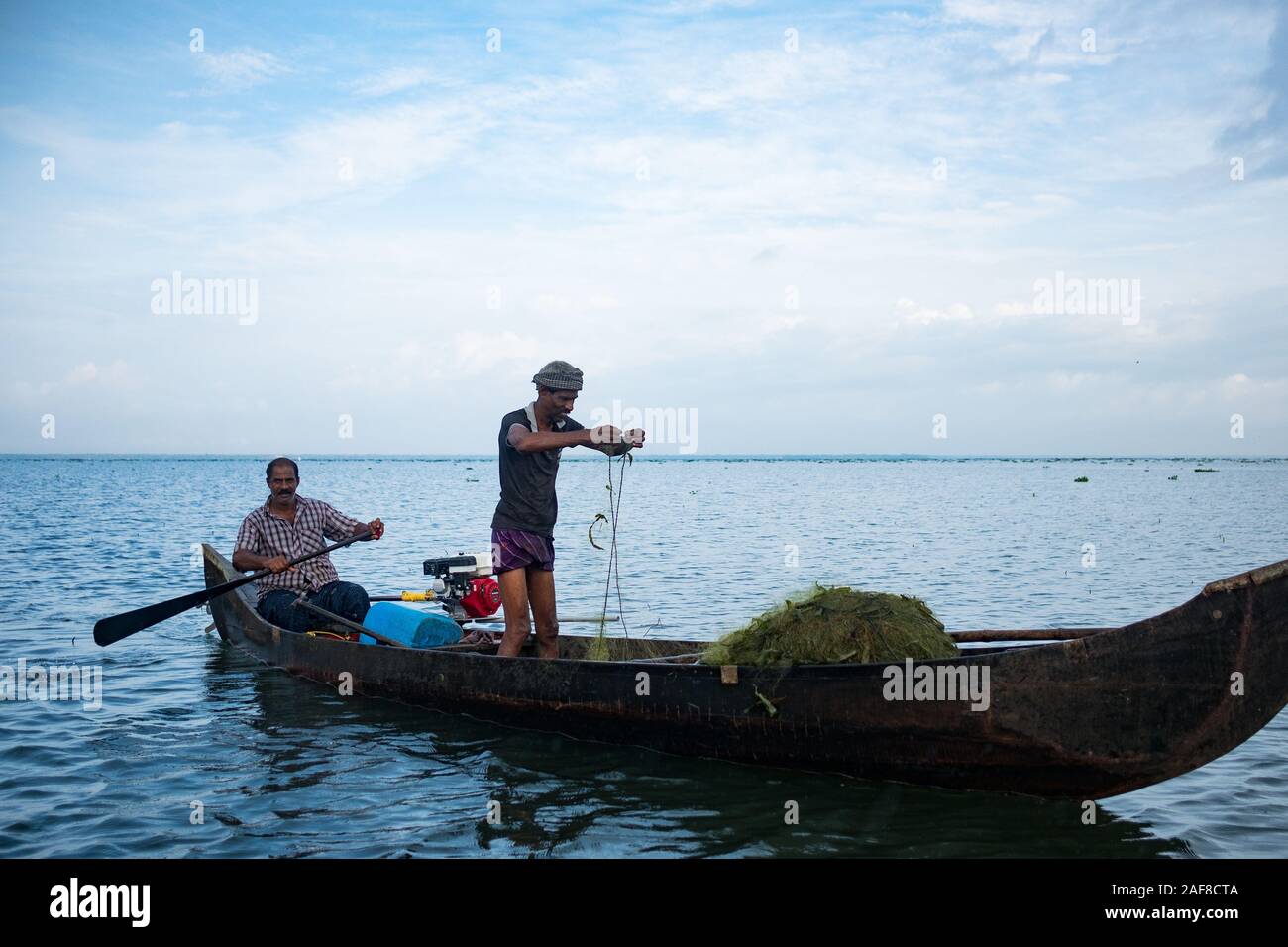 Lago Vembanad, Kerala - 20 ottobre 2019: ritratto di un pescatore indiano su una barca da pesca con reti da posta, un simbolo di economia indiana e la crisi alimentare assortiti Foto Stock