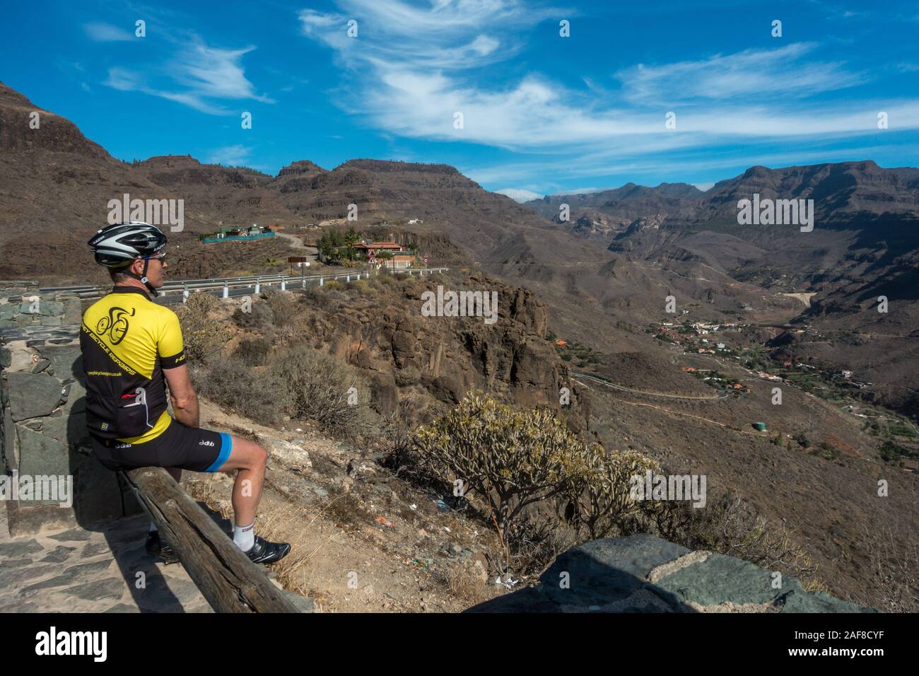 Ciclista godendo la vista dal Mirador de Ayagaures, guardando verso il basso sulla città, GC-503, Ayagaures, Gran Canaria, Spagna Foto Stock