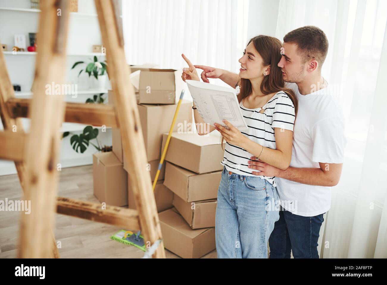 Allegro coppia giovane nel loro nuovo appartamento. Concezione del movimento Foto Stock