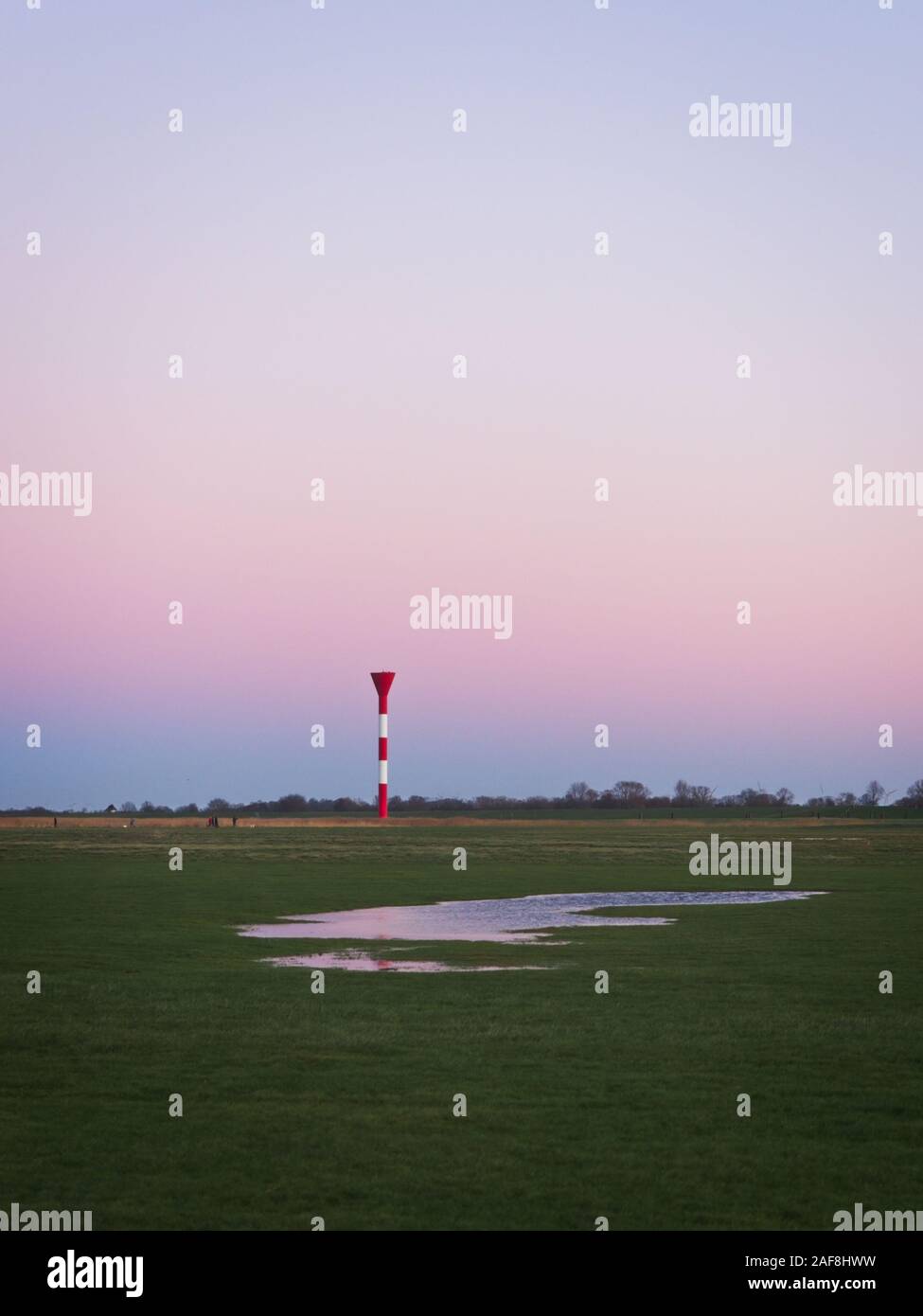 Luce di leader vicino a Cuxhaven al crepuscolo di una bella serata invernale nella parte anteriore di un pastello cielo senza nuvole Foto Stock