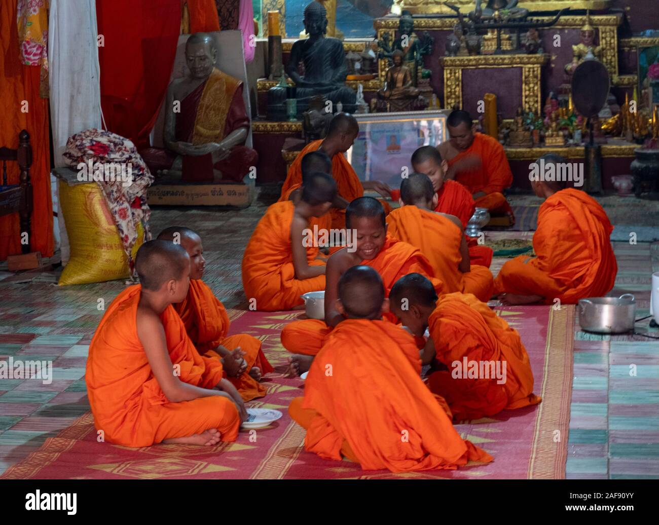 Novizi buddisti che condividono la colazione in una scuola di tempio nella Cambogia rurale Foto Stock